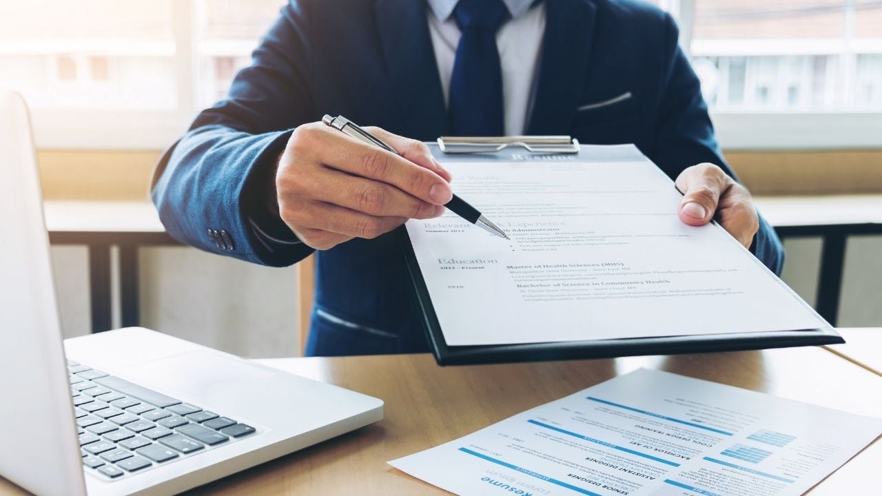 man handing paper and pen 